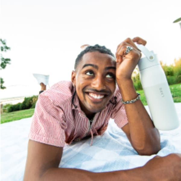 Photo of LARQ Bottle Swig Top - Granite White in mans hand on a picnic