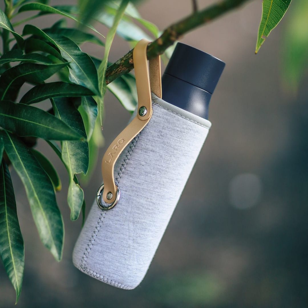 Photo of LARQ Bottle PureVis™ - Monaco Blue in Travel Sleeve hanging on a tree